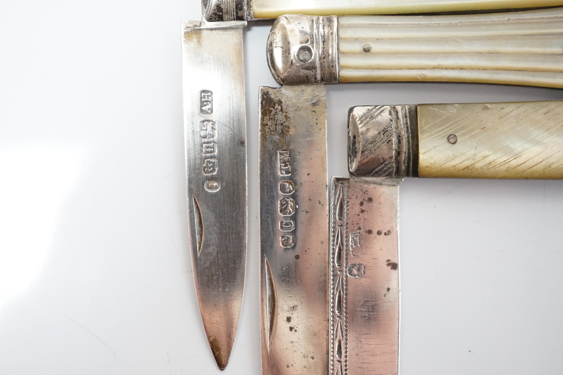 A collection of six assorted Victorian mother of pearl and silver bladed pocket fruit knives, a similar white metal fruit knife and a silver pin case. Condition - poor to fair